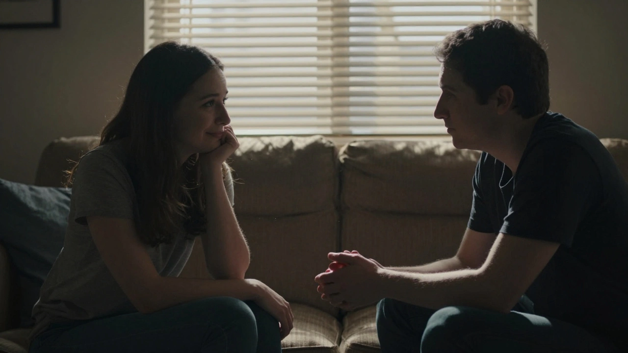 Two people in a quiet room, one avoiding eye contact while the other holds their hand in silent understanding.